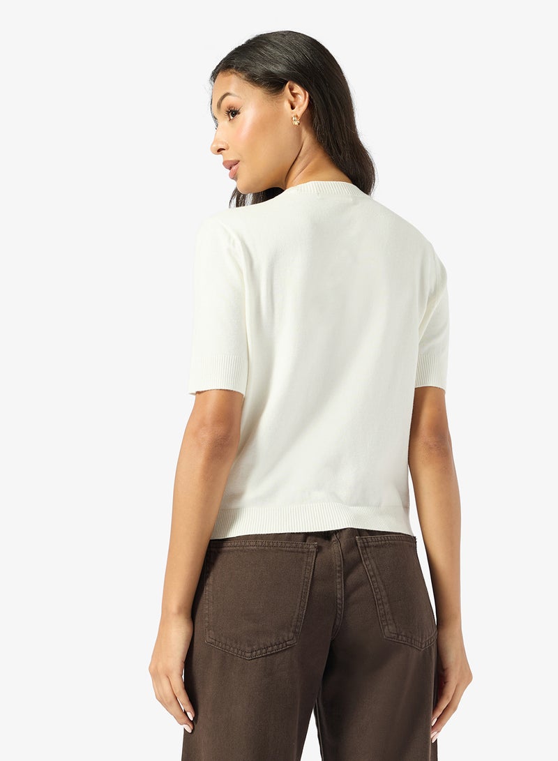 جس كنزة بولوفر قصيرة الأكمام بياقة دائرية وشعار نورة - Image 2